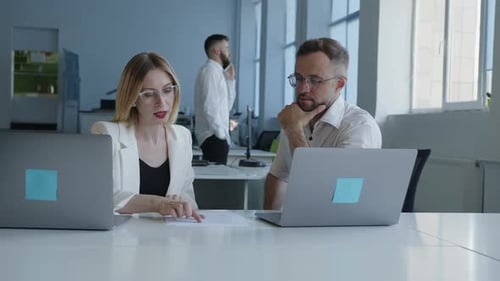 Professionals Collaborating on Project in Modern Office