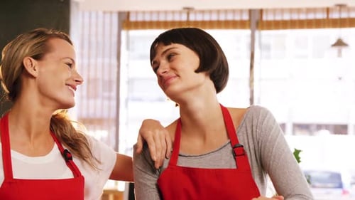 Two waitresses standing together in cafe