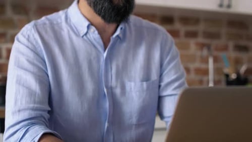 Tilt up video of man working at home office. Shot with RED helium camera in 8K.