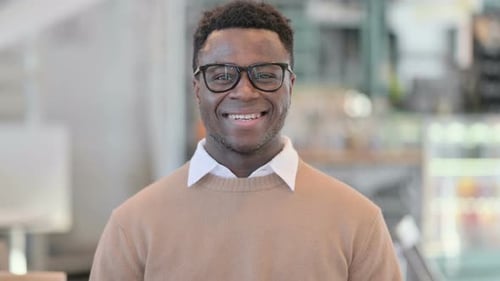 Young Man Smiling at the Camera Indoors
