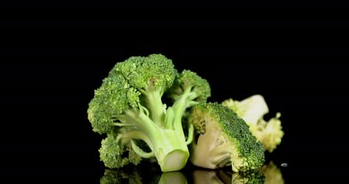 Broccoli Florets on a Black Reflective Surface