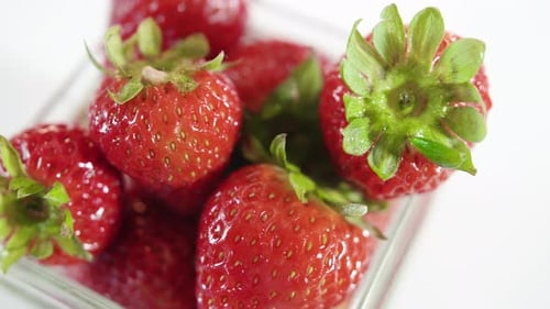 Close Up Rotating Glass Jar Full Of Fresh Ripe Strawberries With White Background Pass By Camera