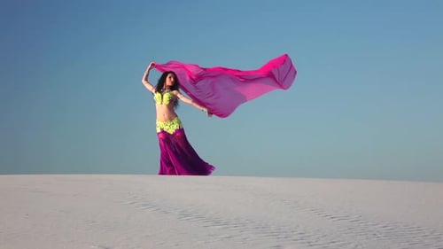 Professional Dancer in the Sandy Desert in the Hands of a Pink Pink Veil, Slow Motion