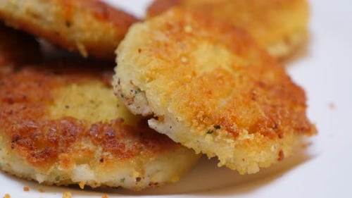 In vegetable oil deep fried fish burger pieces close-up 4K 2160p 30fps UltraHD tilting video - Fried