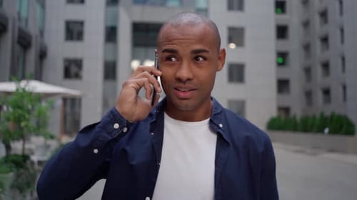 Ethnic Man Answering Phone Call on Street