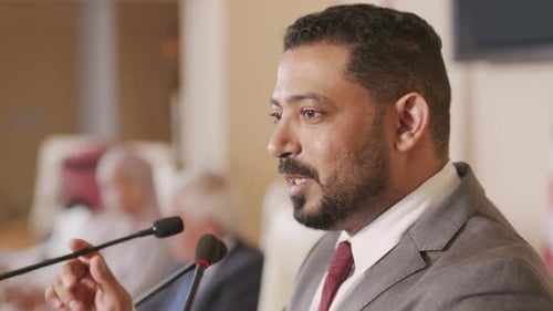 Man Giving Speech with Microphones at Corporate Event