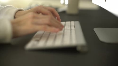 Hands Typing on a Wireless Keyboard at Desk