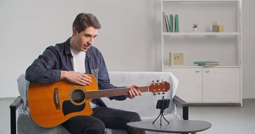 Man Teaching Guitar Online with Smartphone