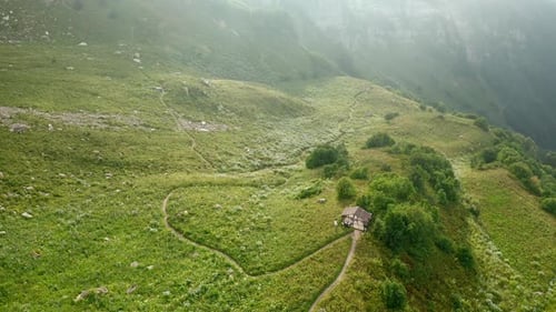 Paysage avec maison rurale sur une colline verdoyante au sommet d'une vieille montagne
