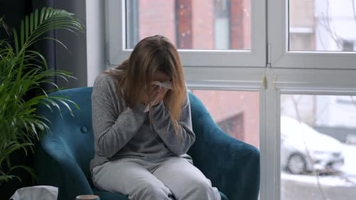 Woman Sneezing and Blowing Nose on Winter Day