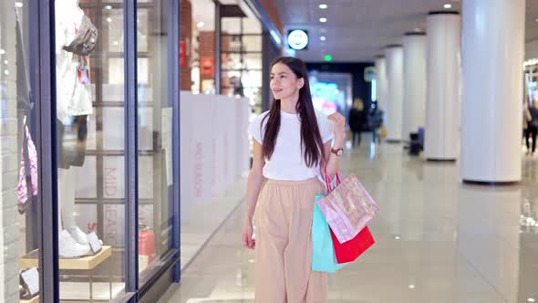 Cover for Brunette Shopaholic Walking Along Stores in Shopping Mall