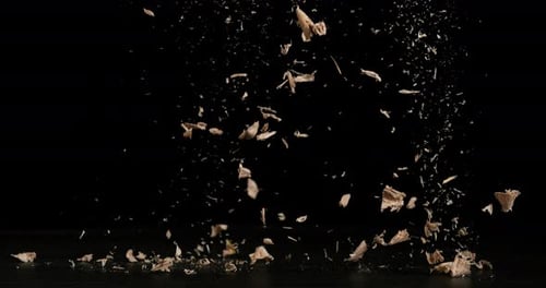 Wood Chips Falling against Black Background, Slow Motion 4K