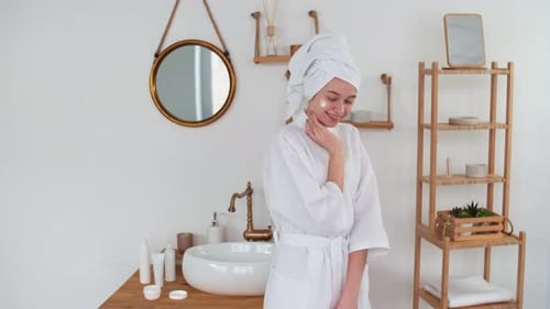 Woman Applying Cream in Bright Bathroom