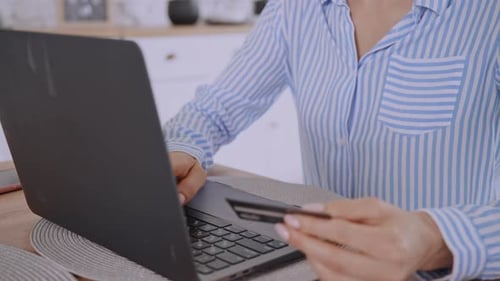 Woman Pays Online with Credit Card on Laptop