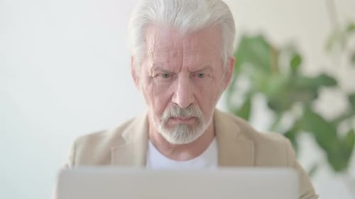 Close Up of Old Man Using Laptop in Office