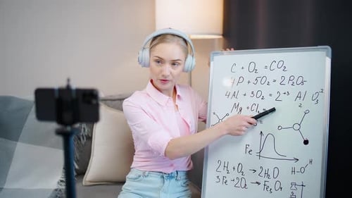 Woman Explains Chemistry Formulas on Whiteboard in Home
