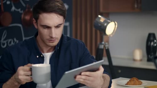 Portrait of Focused Business Man Using Tablet Computer at Home Office.