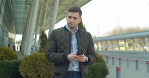 Young Man at the City Street Using Mobile Phone, Typing Text, Chatting with Friends, Man