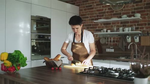 Woman Cutting Bread in Modern Kitchen