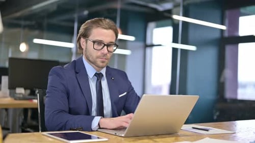 Businessman Working on Laptop on Office Desk