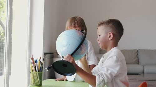 Children Learning Geography With Globe in Sunny Room