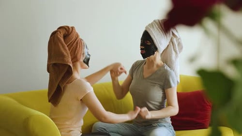 Women With Face Masks Chatting On Sofa