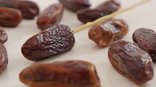 Dried dates palm exotic fruit on white reflective surface 4K 2160p UltraHD footage - Phoenix dactyl