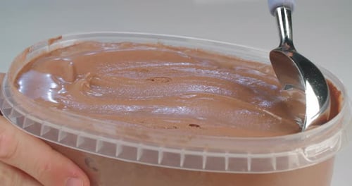 Chocolate ice cream with ice cream scoop in slow motion