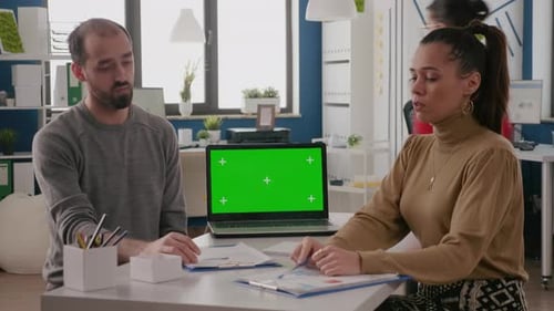 Team of Workers Having Laptop with Green Screen Vertically on Desk