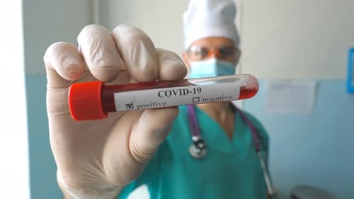 COVID-19 Test Tube Held by Health Worker