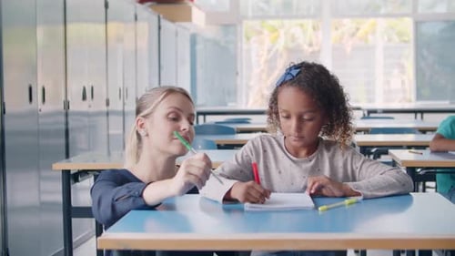 Friendly Female School Teacher Helping Black Schoolgirl