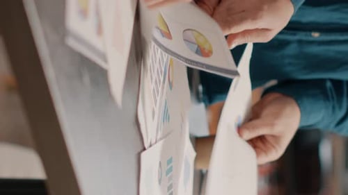 Close Up of Colleagues Analyzing Data Rate Charts on Papers