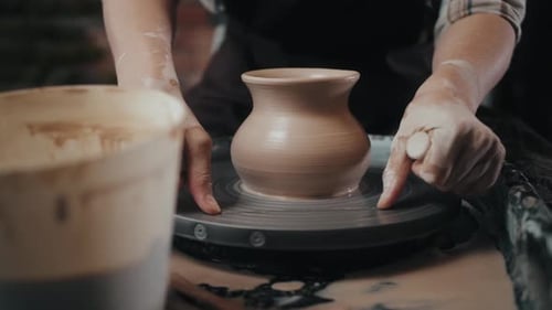 Homme potier travaillant sur le tour de potier fabriquant un pot en céramique à partir d'argile dans un atelier de poterie