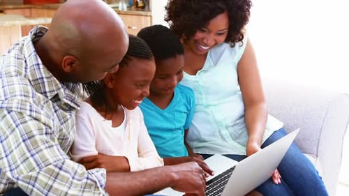Family using laptop in living room