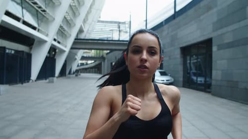 Woman Jogging Towards Camera in Urban Setting