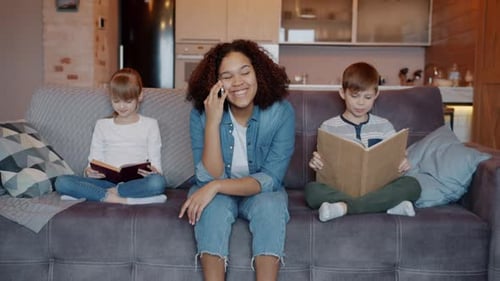 Young Woman on Phone, Kids Read Books at Home