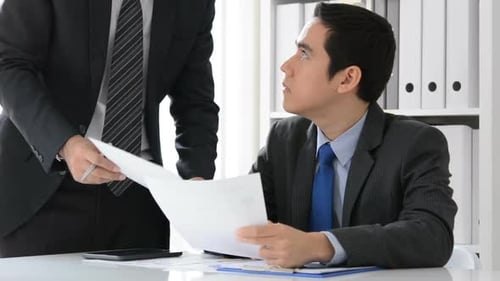 Businessmen seriously discussing documents in the office