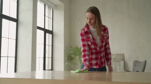 Woman Cleaning Table in Bright Modern Home