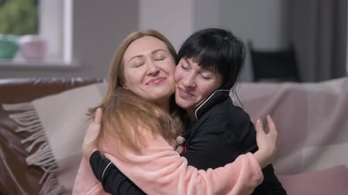 Two Women Friends Embracing Affectionately on Couch