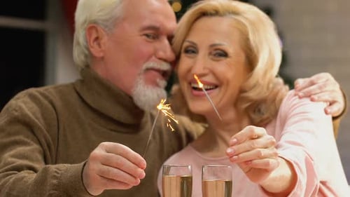 Senior Couple Celebrating with Sparklers at Christmas