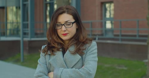 Business Woman with Glasses Standing Look at Camera Serious Near Business Center