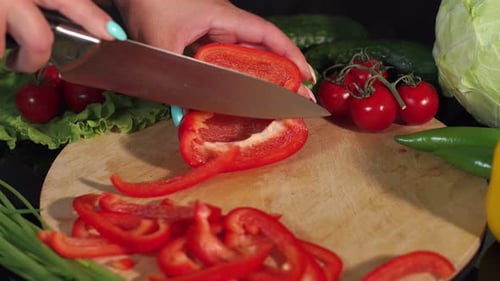 Hands Slicing Red Pepper on Cutting Board