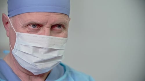 Médico idoso realizando cirurgia