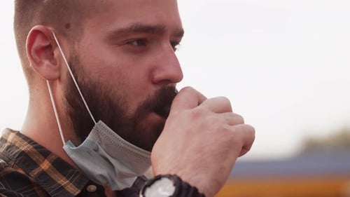 Man Vaping with Mask Hanging Below Chin