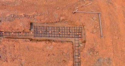 En un sitio de construcción, el acero se coloca en una zanja para los cimientos