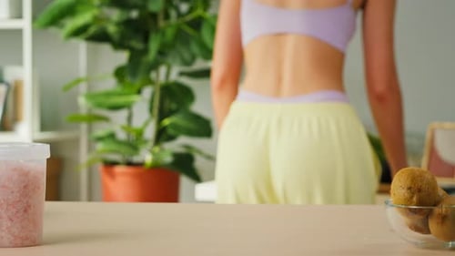 Athletic Woman Places Vegetables on the Table