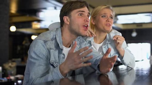 Couple At Bar Watching Sporting Event Together