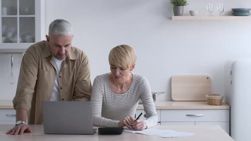 Adults Reviewing Finances at Kitchen Table