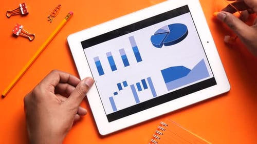 Top View of Man Hand Analyzing Financial Charts on Digital Tablet