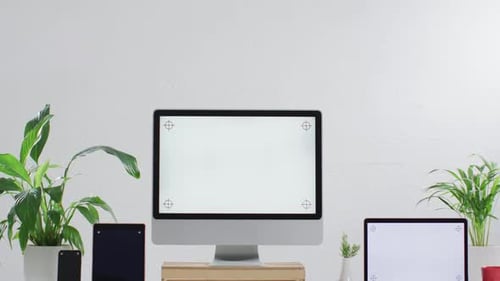 Video of laptop, smartphone, tablet and computer on wooden table with copy space in office